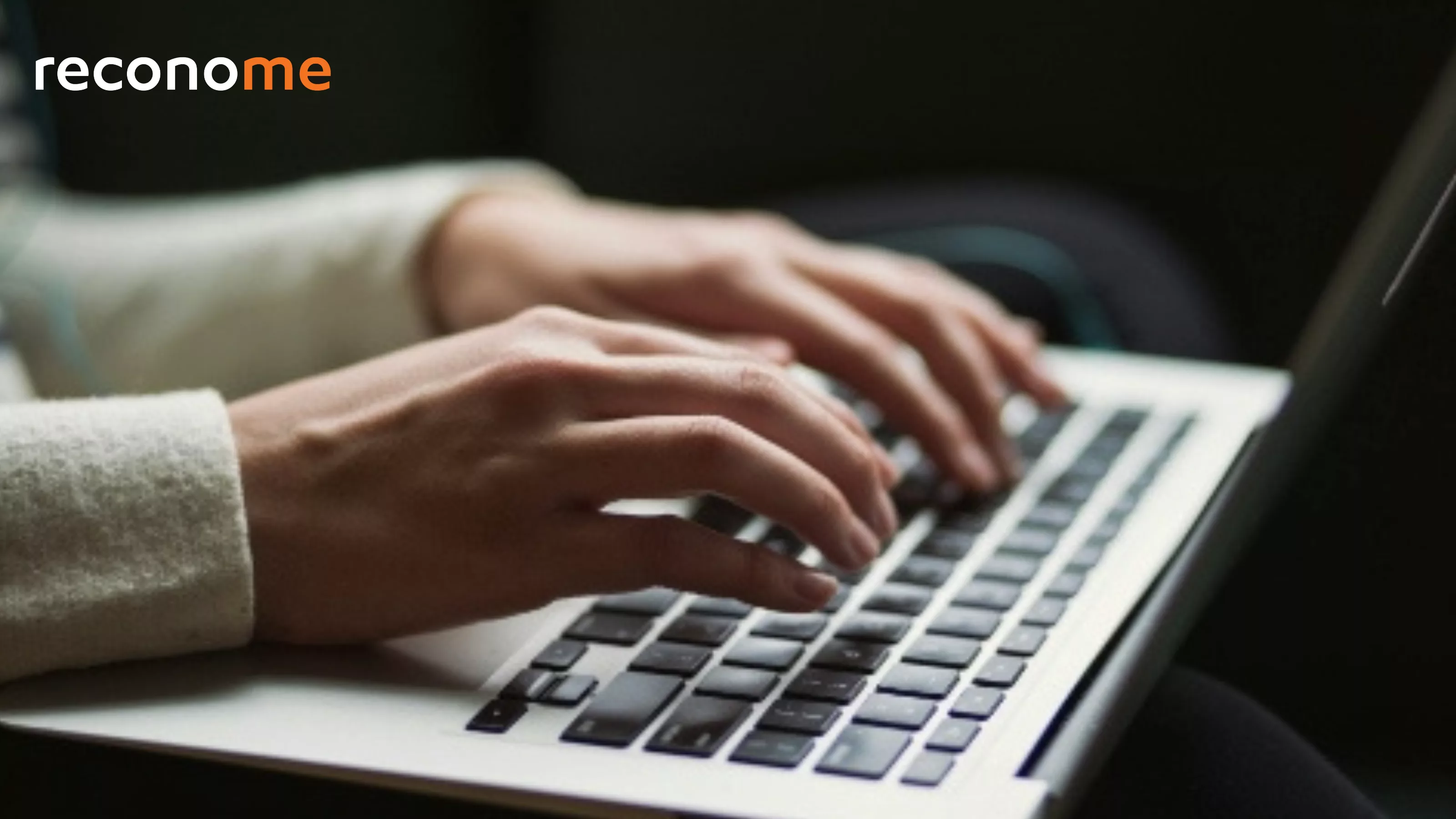 Hands typing on a laptop keyboard.