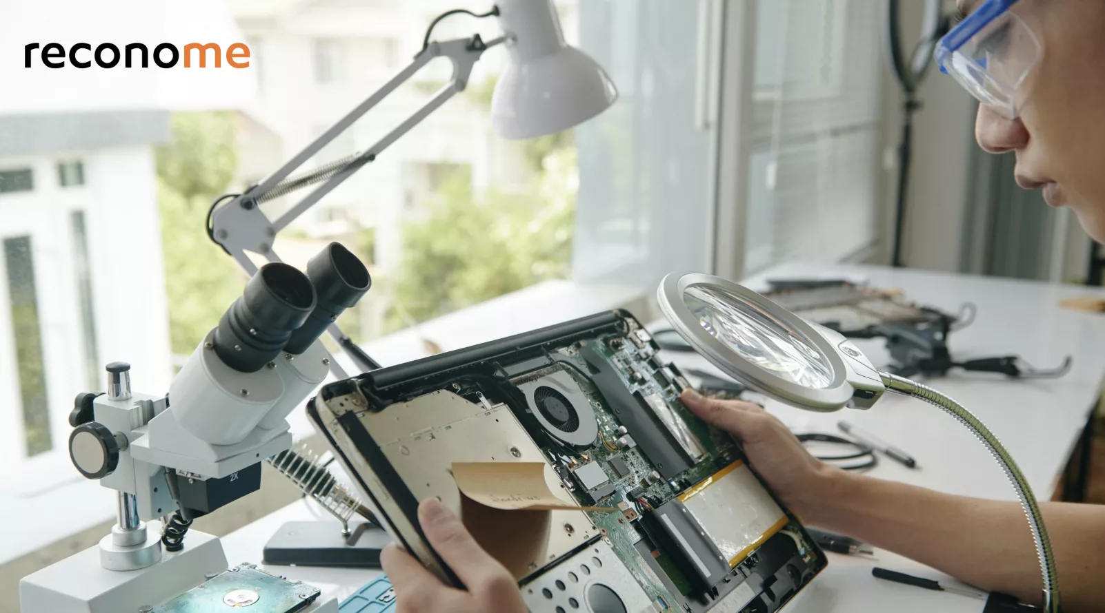 Electronics being repaired under a magnifier.